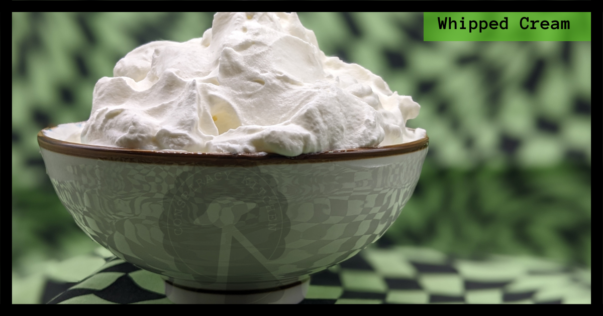 Close up of the whipped cream in a small bowl on a green and black background.